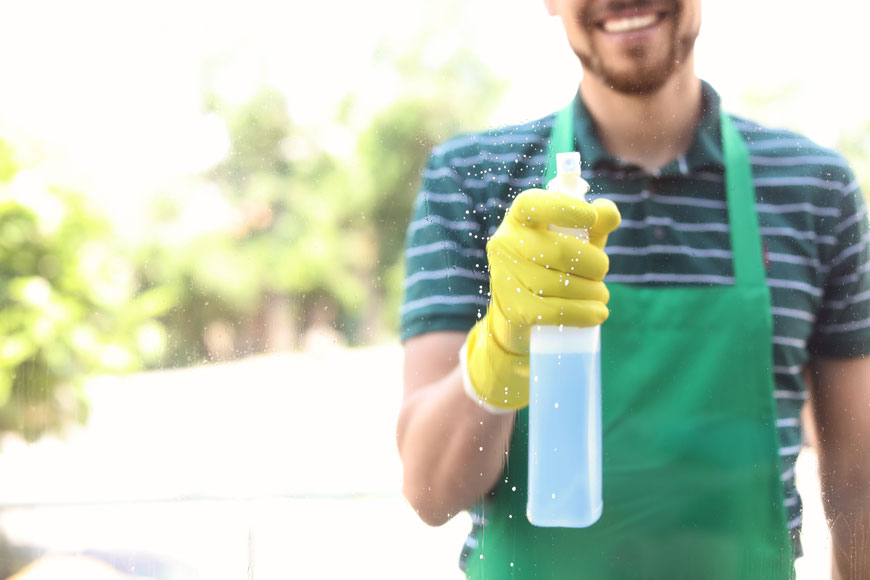 A picture of a man using a spray bottle